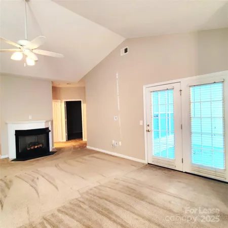 a view of an empty room with a fireplace and a window