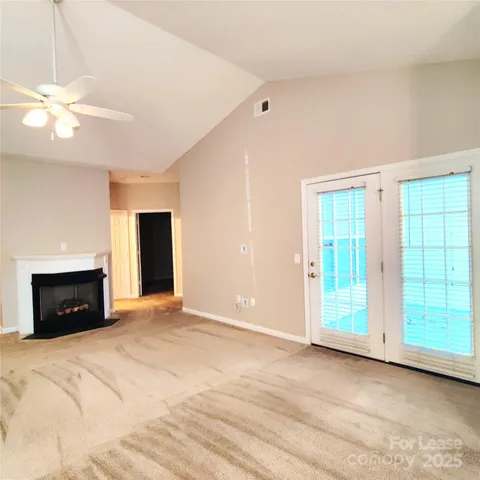 a view of an empty room with a fireplace and a window