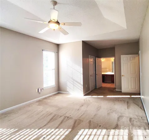 a view of an empty room with window and cabinet