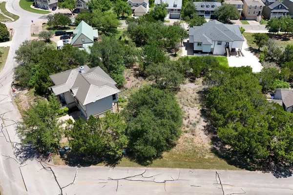 an aerial view of ocean and residential houses with outdoor space