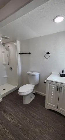 a bathroom with a toilet a sink and shower