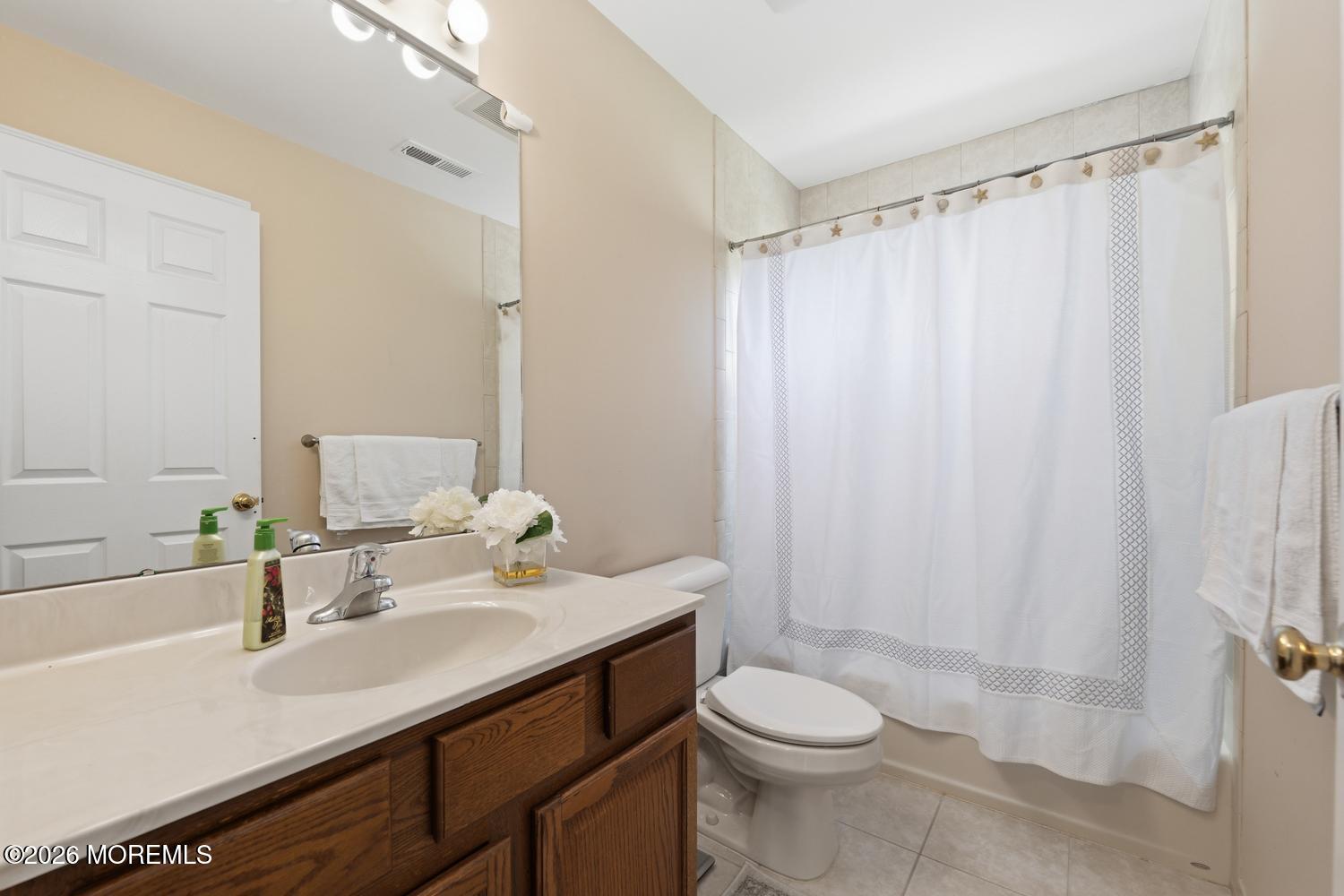 7 Cherry Tree Lane Cream Ridge, NJ 08514 - Photo 32 of 47 a bathroom with a sink a toilet a mirror and shower curtain