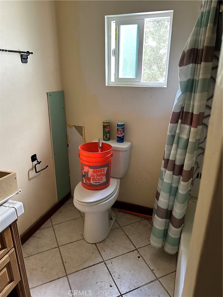 34930 East Benton Road Hemet, CA 92544 - Photo 26 of 54 a white toilet sitting next to a bathroom sink and a mirror