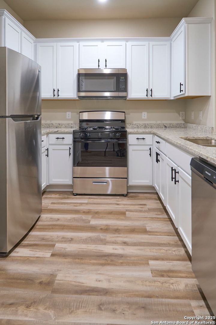 482 Abigail Alley San Antonio, TX 78253 - Photo 7 of 27 a kitchen with granite countertop white cabinets and stainless steel appliances
