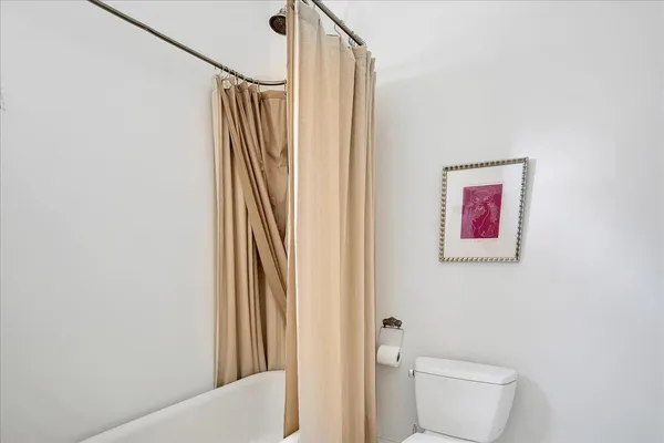 a bedroom with a bed a mirror and a flat tv screen on dresser