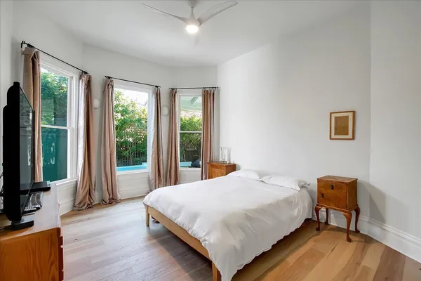 a view of a room with wooden floor and two windows