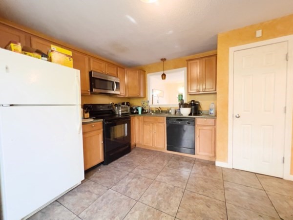 45 Lawn Street, Unit PE Boston, MA 02120 - Photo 5 of 26 a kitchen with granite countertop a refrigerator and a stove top oven