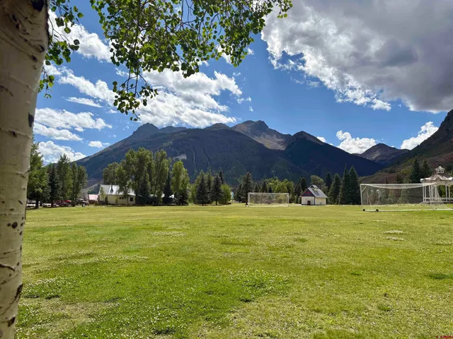 a view of big yard with a house in the background