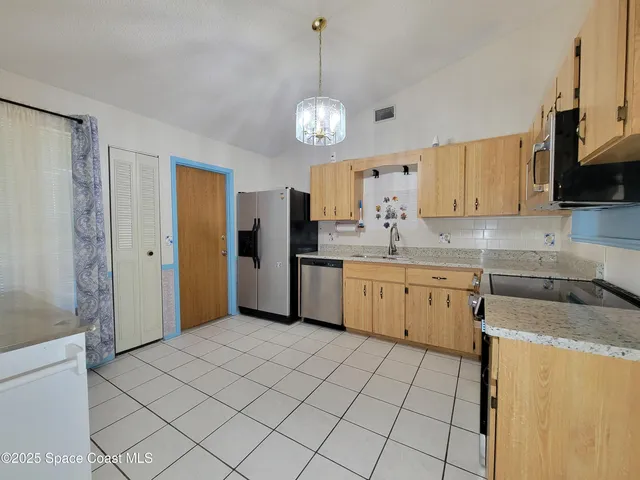 a kitchen with granite countertop cabinets a sink a window and stainless steel appliances
