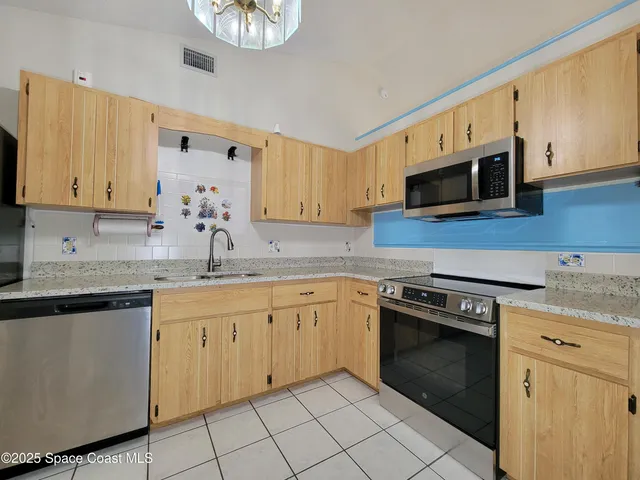 a kitchen with granite countertop white cabinets and stainless steel appliances