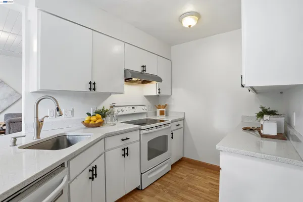a kitchen with a sink a stove and cabinets