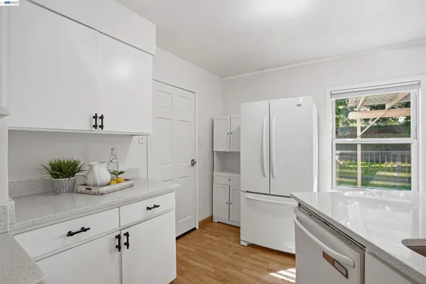 a kitchen with a refrigerator and white cabinets
