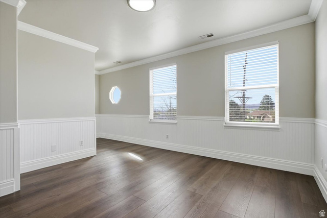 4496 West 11800 South South Jordan, UT 84009 - Photo 4 of 33 Empty room with crown molding, dark wood-type flooring, and a wainscoted wall