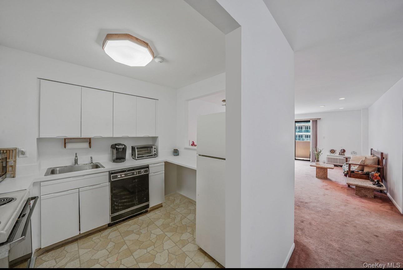 360 Shore Road, Unit 4B Long Beach, NY 11561 - Photo 14 of 28 Kitchen featuring light countertops, light colored carpet, white cabinets, and white appliances