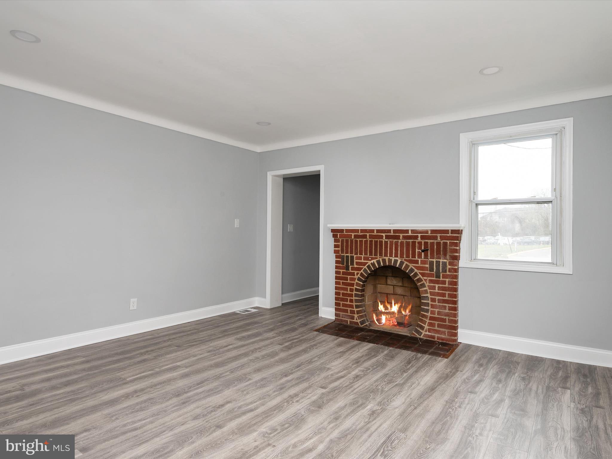 5002 Silver Hill Road Suitland, MD 20746 - Photo 8 of 39 a view of an empty room with wooden floor fireplace and a window