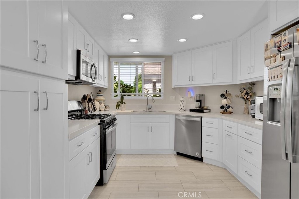 12 Sparrow Hill Lane Laguna Hills, CA 92653 - Photo 23 of 45 a kitchen with white cabinets and white appliances