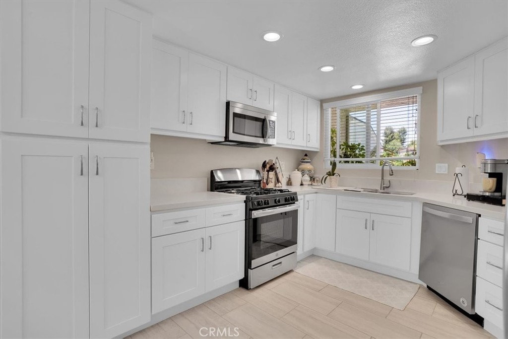 12 Sparrow Hill Lane Laguna Hills, CA 92653 - Photo 24 of 45 a kitchen with white cabinets appliances and a sink