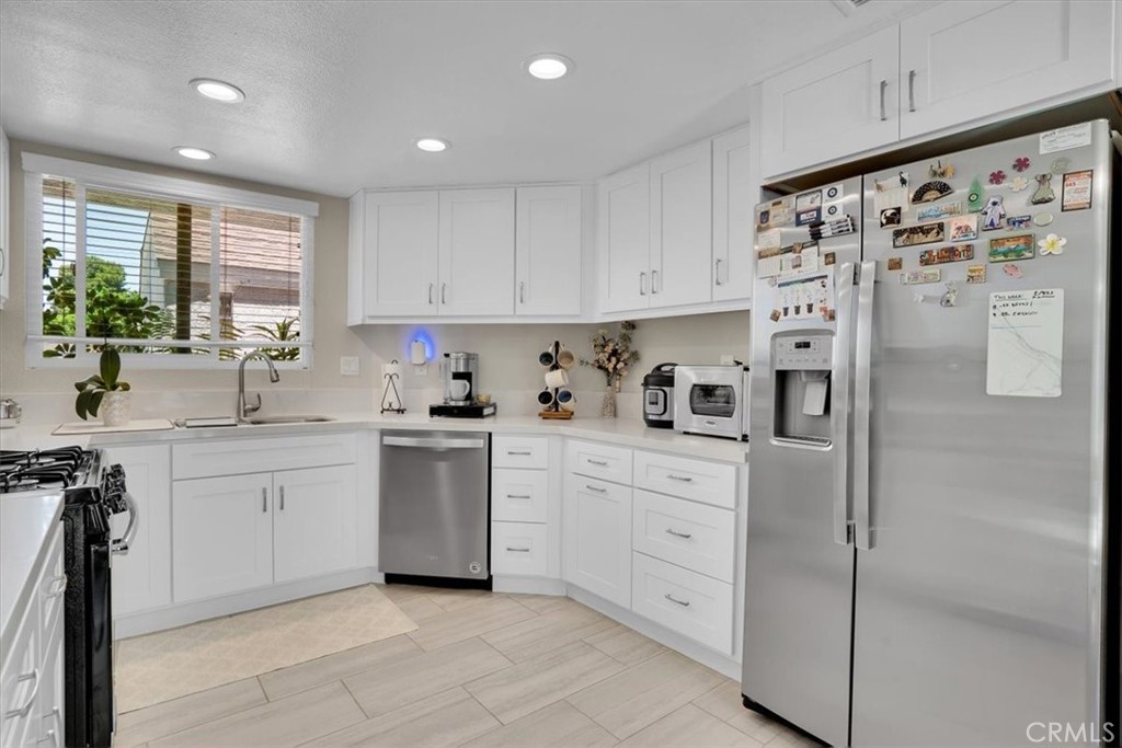 12 Sparrow Hill Lane Laguna Hills, CA 92653 - Photo 25 of 45 a kitchen with white cabinets and white appliances