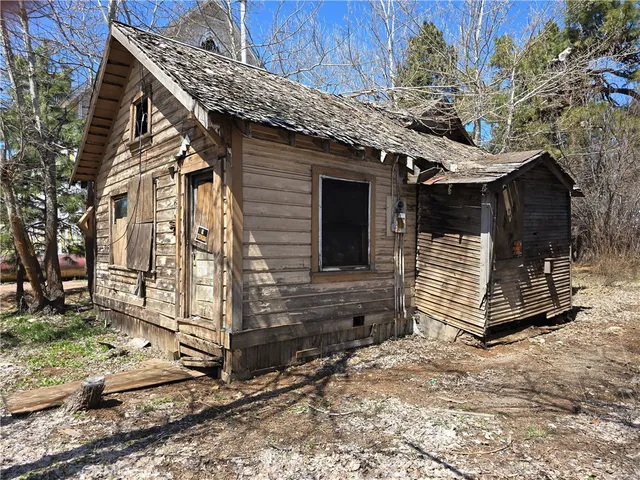 a view of a house with a yard and wooden fence