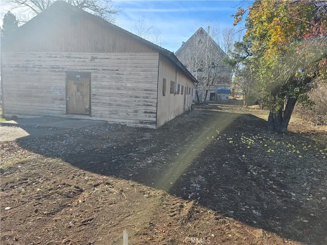 a view of a grey house with a yard