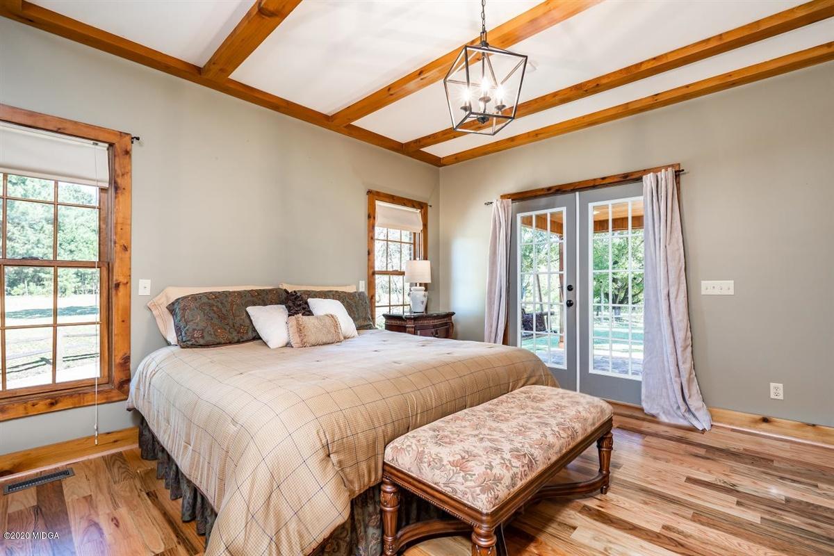 545 Gose Road Forsyth, GA 31029 - Photo 16 of 36 a bedroom with a bed a dresser and wooden floor