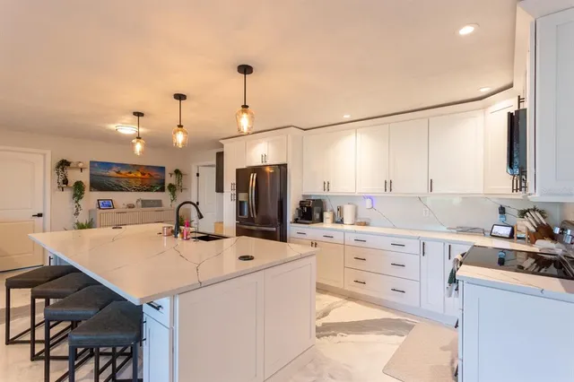 a kitchen with a sink a stove and chairs