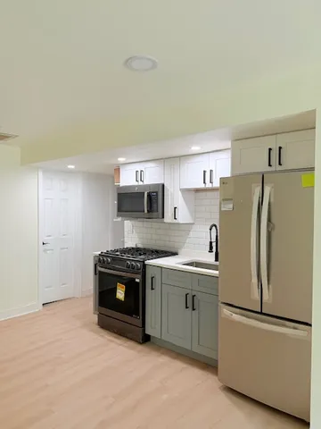 a kitchen with appliances a sink and a refrigerator