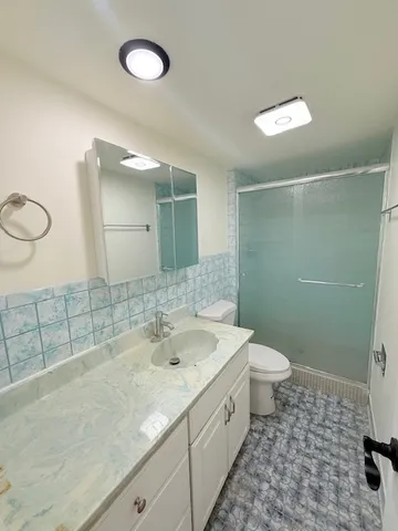a bathroom with a sink a toilet and a shower