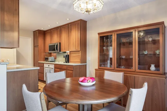 a kitchen with a dining table chairs and refrigerator