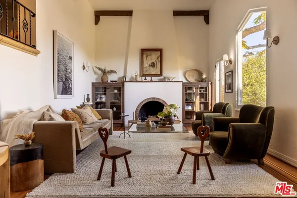 a living room with furniture a large window and a fireplace