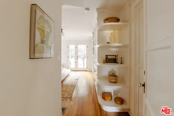 a view of a hallway with wooden floor and front door