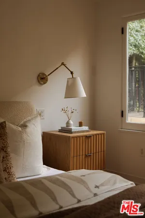 a bed sitting in a bedroom next to a window