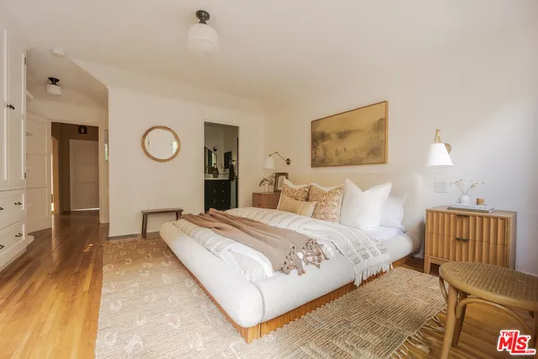 a spacious bedroom with a bed and a lamp