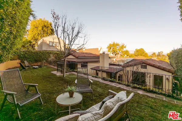 a backyard of a house with table and chairs