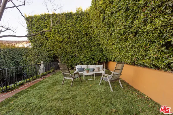 a view of a chairs and table in the backyard