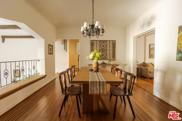 a view of a dining room with furniture a chandelier and wooden floor