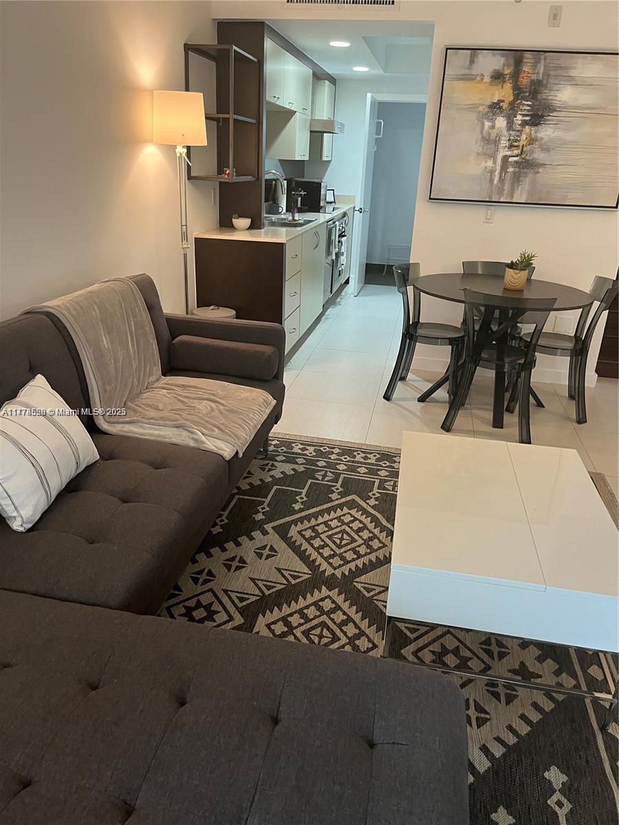 2130 Park Avenue, Unit 4 Miami Beach, FL 33139 - Photo 4 of 12 a living room with a couch and a dining table with wooden floor