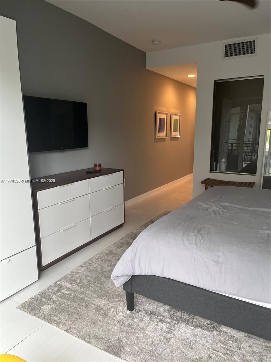 2130 Park Avenue, Unit 4 Miami Beach, FL 33139 - Photo 10 of 12 a spacious bedroom with a bed and a flat screen tv