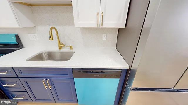 a kitchen with a sink a refrigerator and cabinets