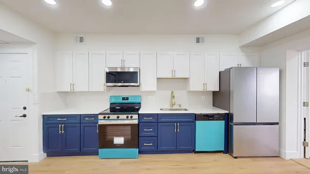 a kitchen with stainless steel appliances granite countertop a refrigerator stove and sink