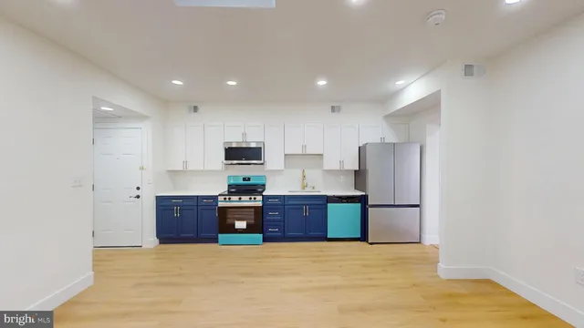 a large kitchen with stainless steel appliances granite countertop a refrigerator and a stove top oven