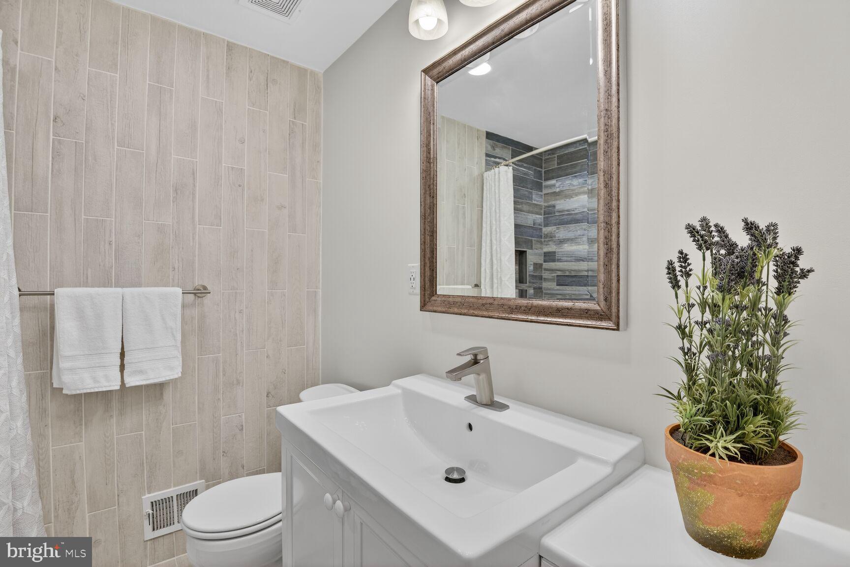 9900 Fernwood Road Bethesda, MD 20817 - Photo 26 of 39 a bathroom with a sink a toilet and a mirror