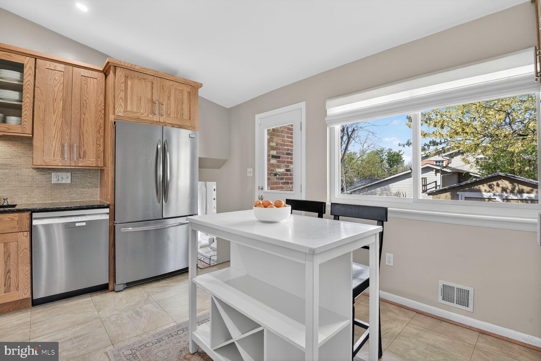 9900 Fernwood Road Bethesda, MD 20817 - Photo 10 of 39 a kitchen with a refrigerator a stove a sink and a large window