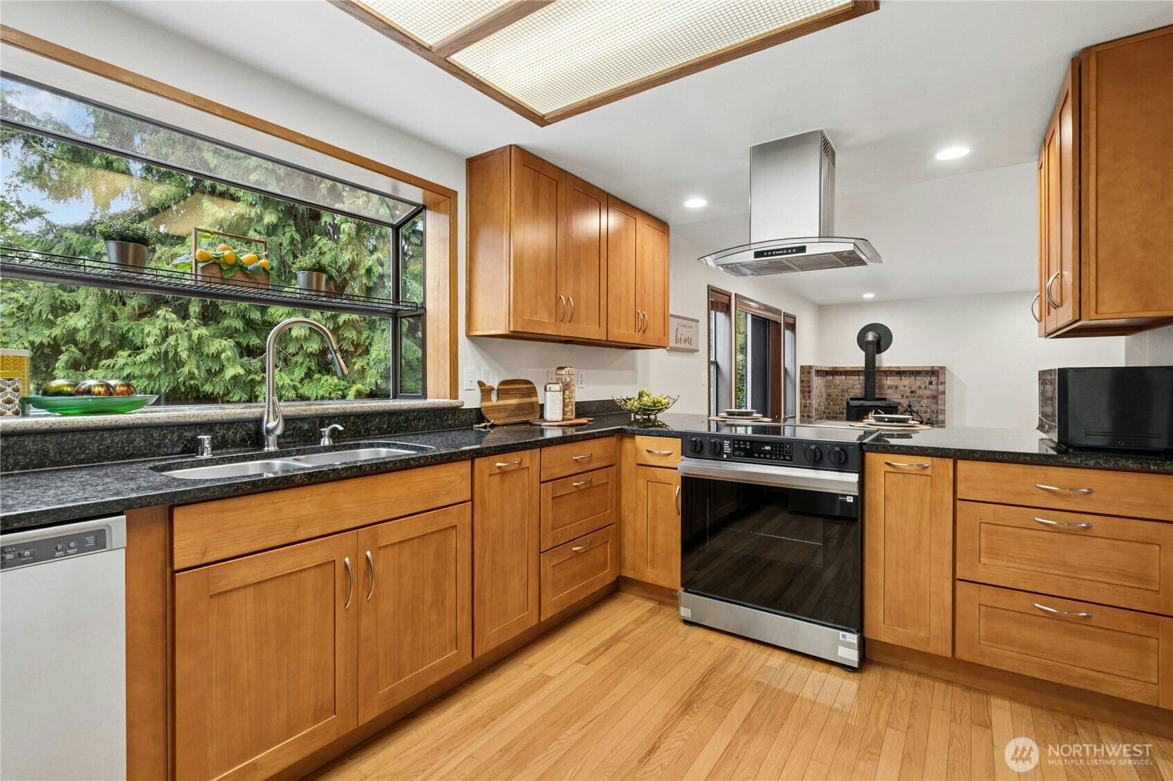 5211 103rd Street Southwest, Unit SW Mukilteo, WA 98275 - Photo 13 of 40 a kitchen with granite countertop wooden floors stainless steel appliances a sink and a window