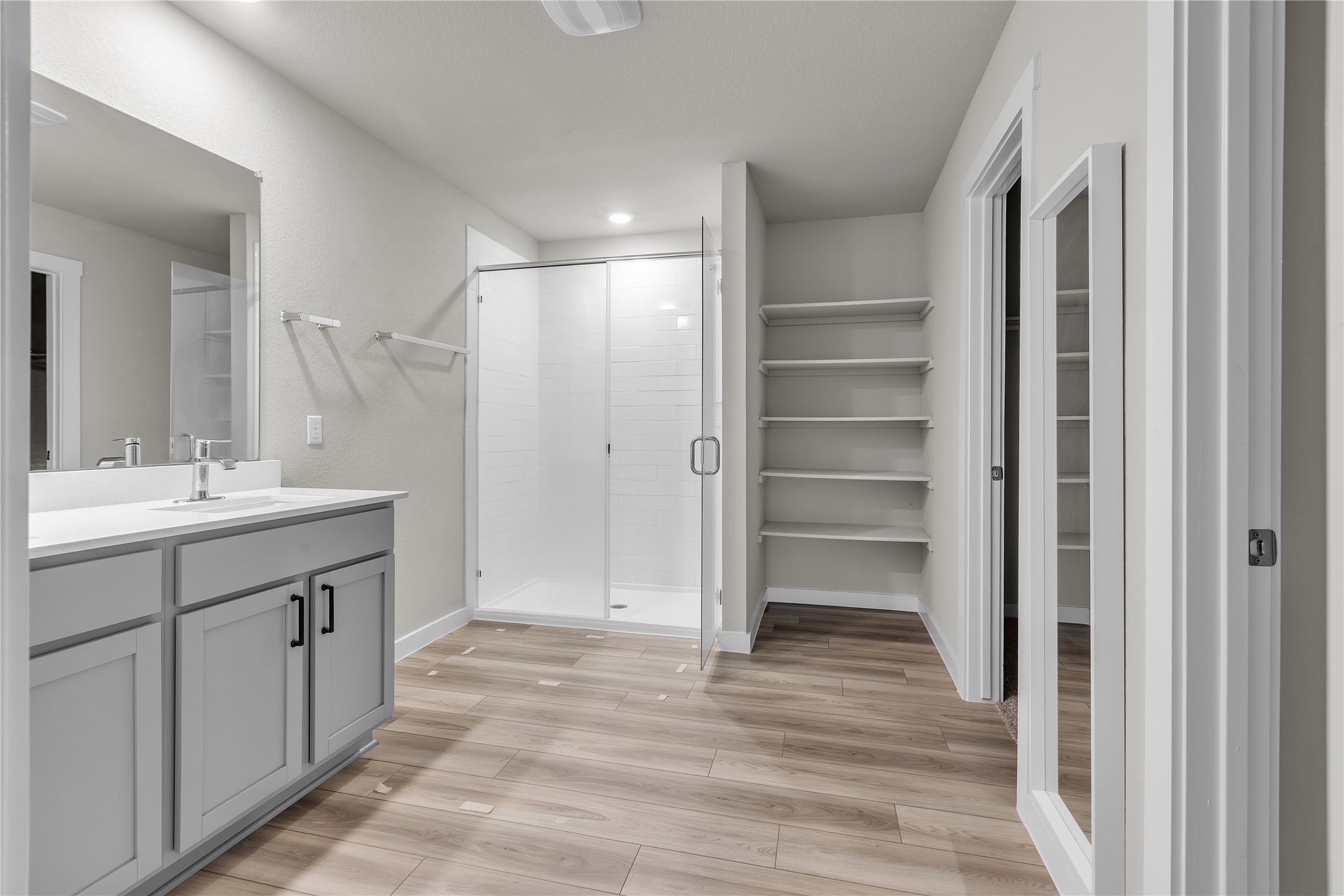 1212 Tipton Street Georgetown, TX 78633 - Photo 12 of 20 A well-lit primary bathroom featuring a spacious walk-in shower and ample shelving for organization.