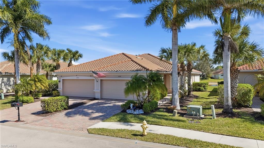 Mediterranean / spanish-style home with decorative driveway, a tile roof, stucco siding, a front lawn, and a garage