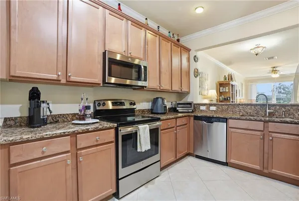 a kitchen with stainless steel appliances granite countertop white cabinets a sink and dishwasher