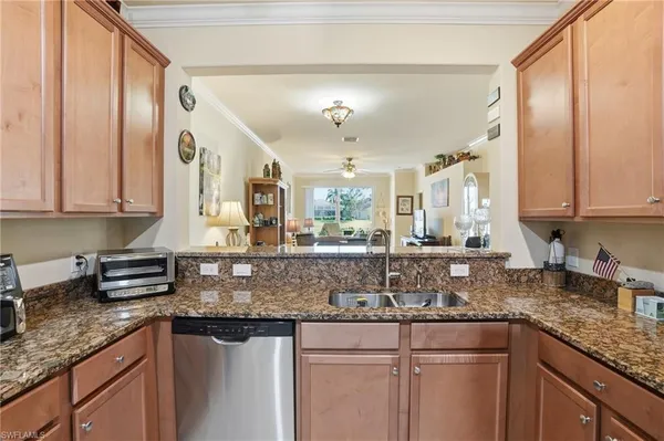 a kitchen with stainless steel appliances granite countertop a sink a stove and a wooden cabinets