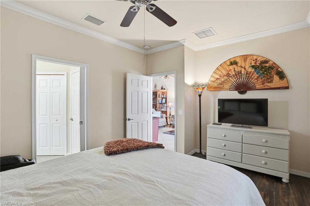 14536 Grapevine Drive Naples, FL 34114 - Photo 23 of 39 Bedroom with crown molding, a ceiling fan, and dark wood-type flooring