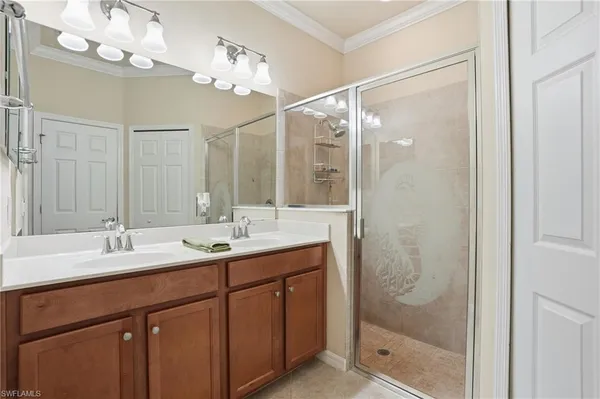 a bathroom with a double vanity sink mirror and shower